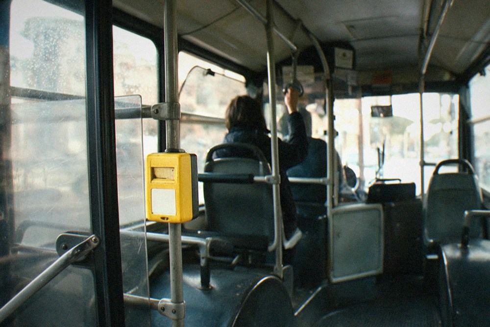 A bus ticket validator machine mounted inside a Rome bus near the doors