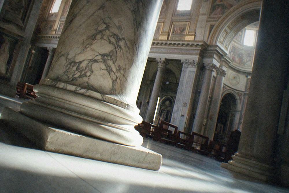 Interior of St Peter's Basilica nave with columns and high ceiling lit from windows