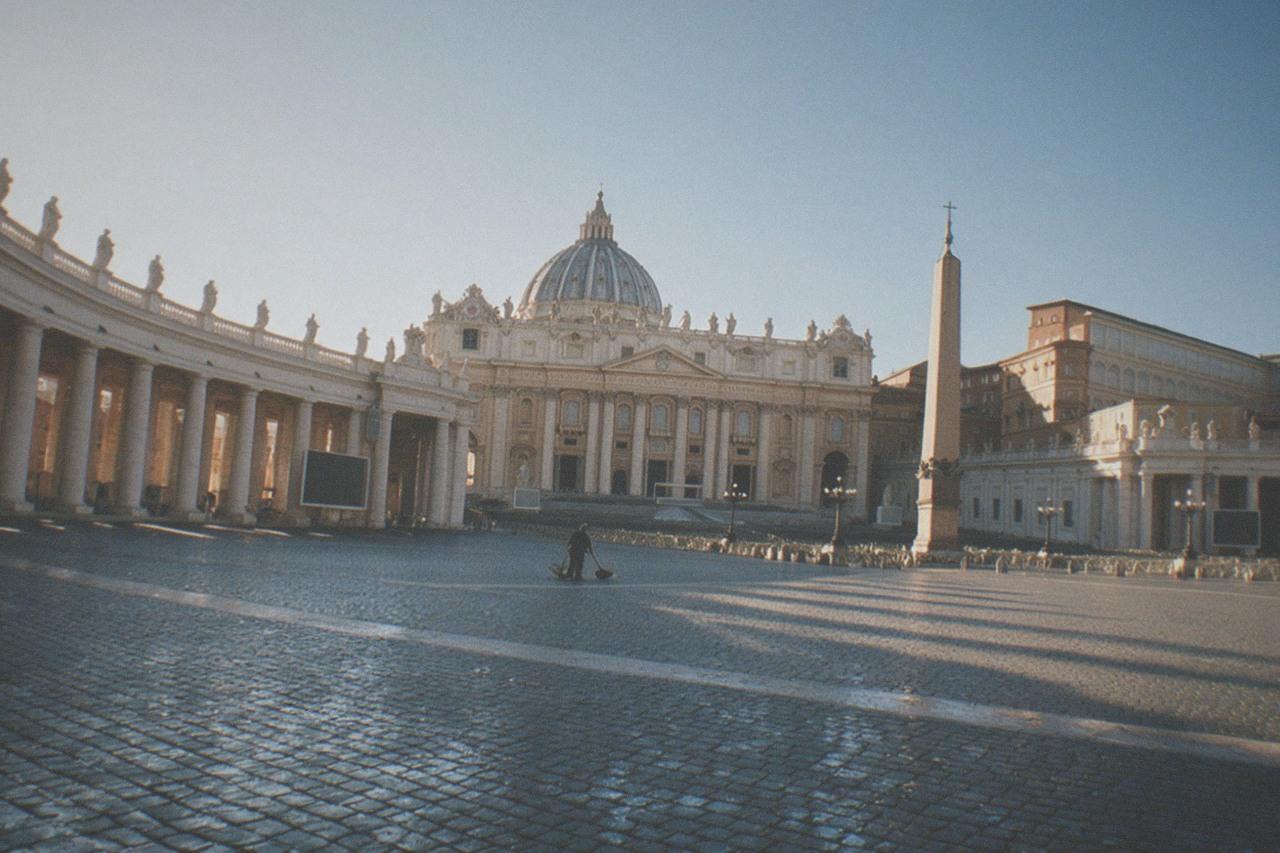St Peter's Square colonnades and basilica facade under a clear sky in early morning light
