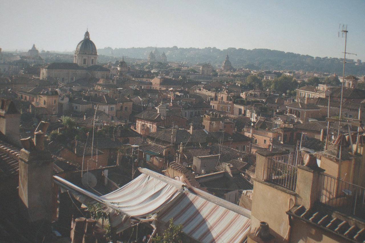 Rooftops and church domes of central Rome seen from a high terrace in morning light