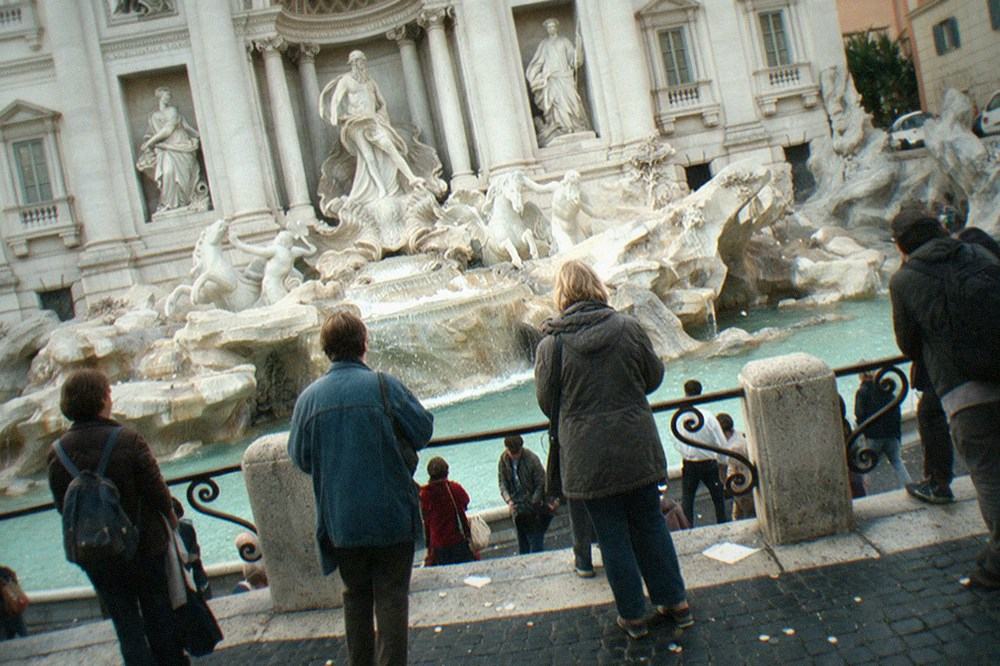 The Trevi Fountain seen from the edge of the square with baroque sculptures in stone