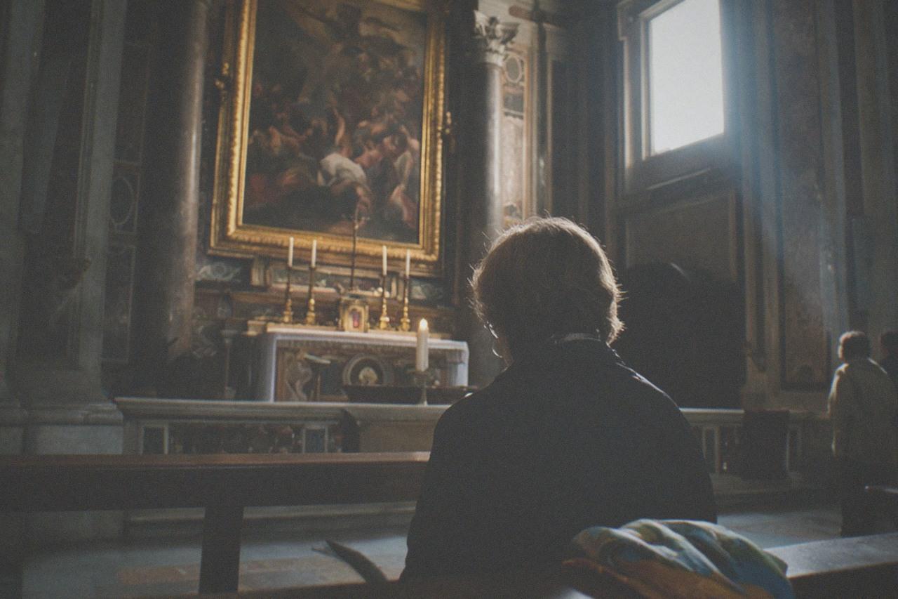 Baroque church interior with oil paintings glowing above a marble altar