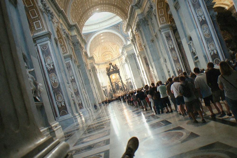 Grand basilica nave with ornate coffered ceiling and rows of columns