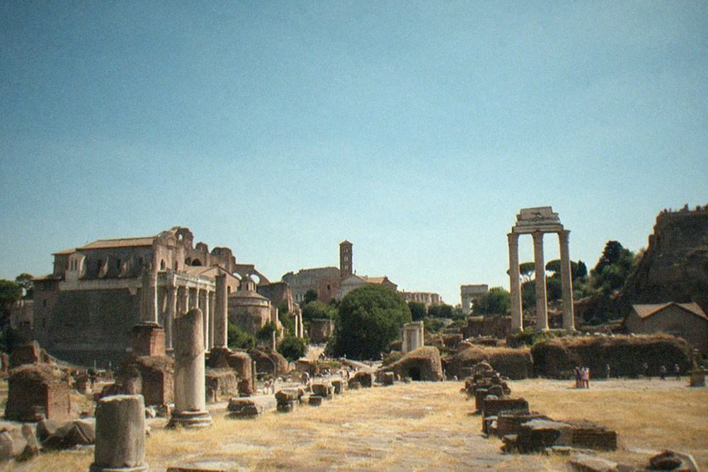 Ancient Roman stone ruins with columns under a wide open sky in an archaeological park