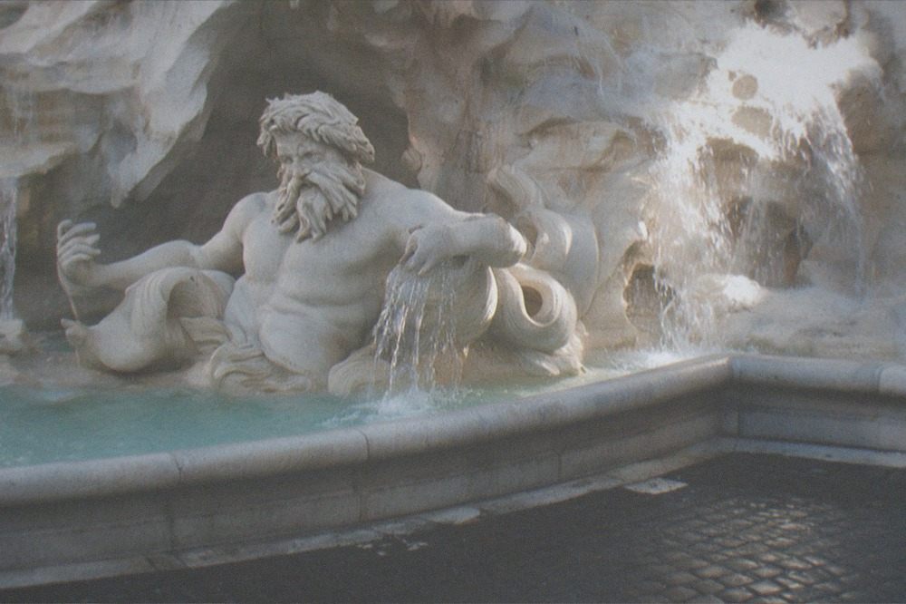 The Trevi Fountain seen from the edge of the square with water cascading