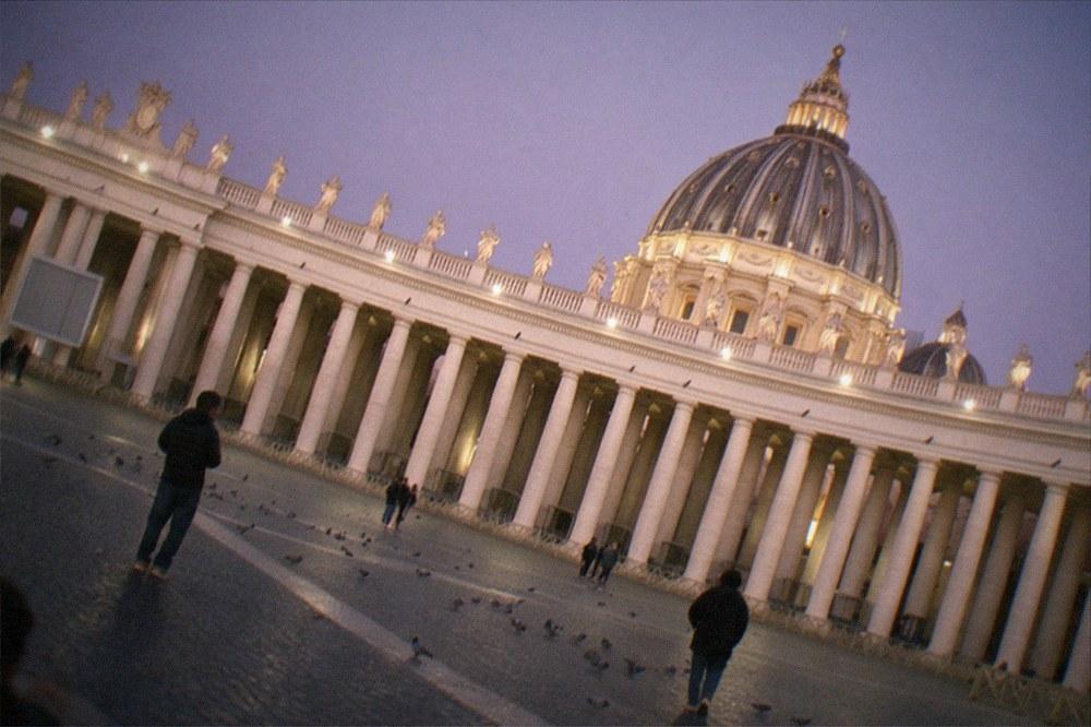 St Peter's Basilica dome rising above the colonnade at dusk