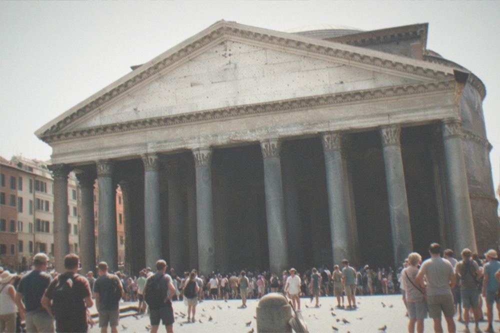 The stone facade and columns of the Pantheon seen across a busy open piazza