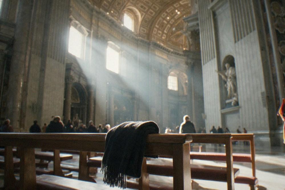 Interior of St Peter's Basilica nave with columns and high ceiling in soft light