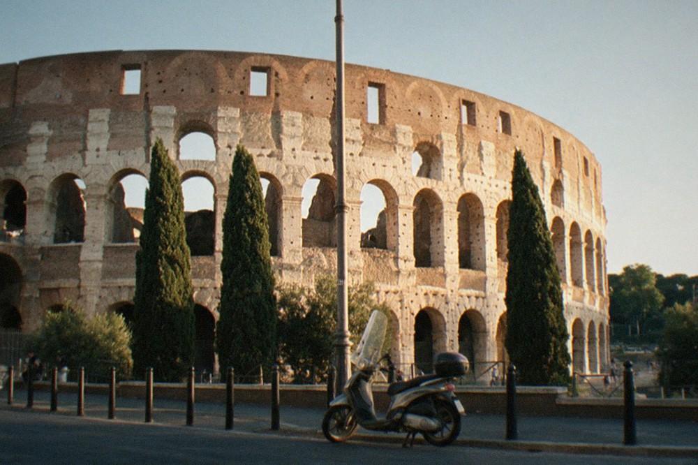 The curved outer wall of the Colosseum seen from the street below