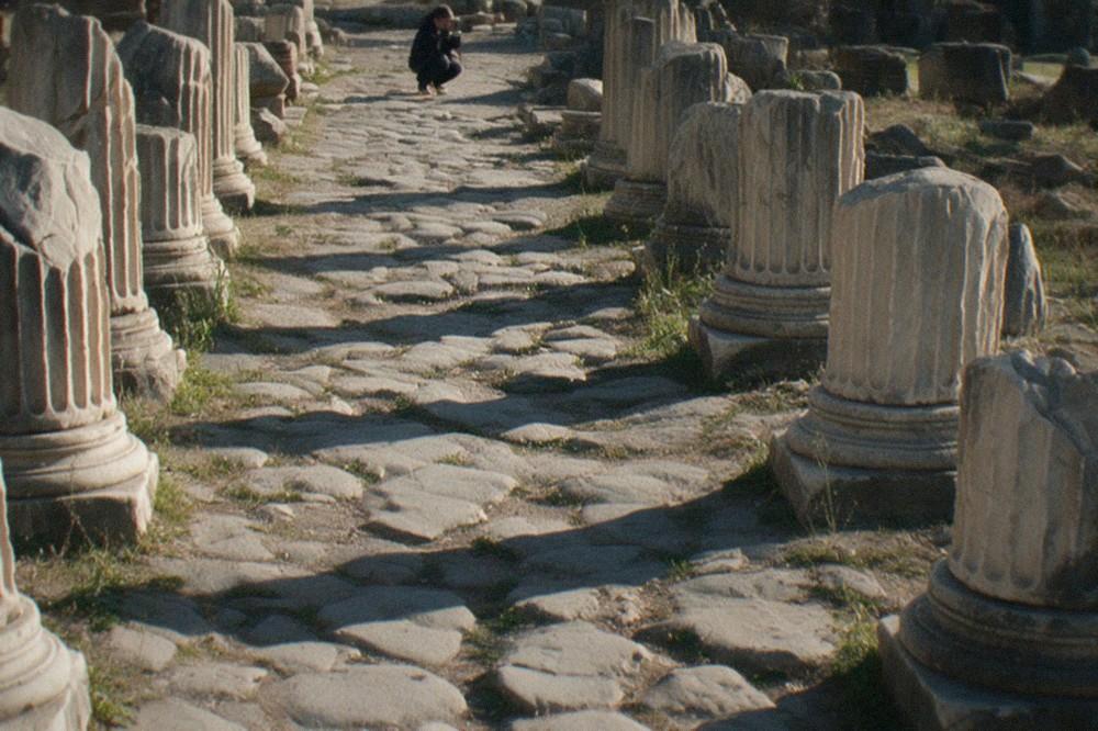 Rows of broken marble columns lining the ancient stone path of the Roman Forum