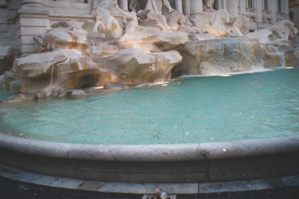 Evening light on the travertine facade and cascading water of the Trevi Fountain