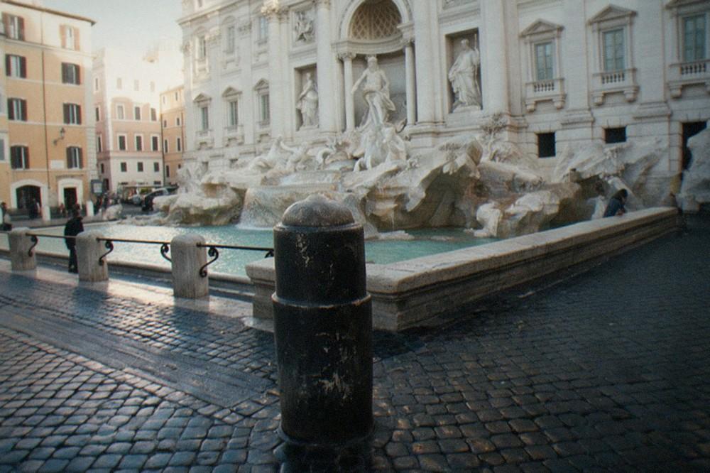 The Trevi Fountain seen from the edge of the square with the baroque facade rising above the water
