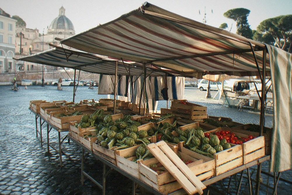 Market stalls under umbrellas in a Roman square at morning