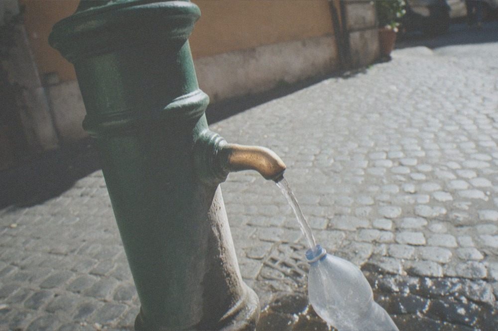 Cast-iron drinking fountain with running water on a Roman street